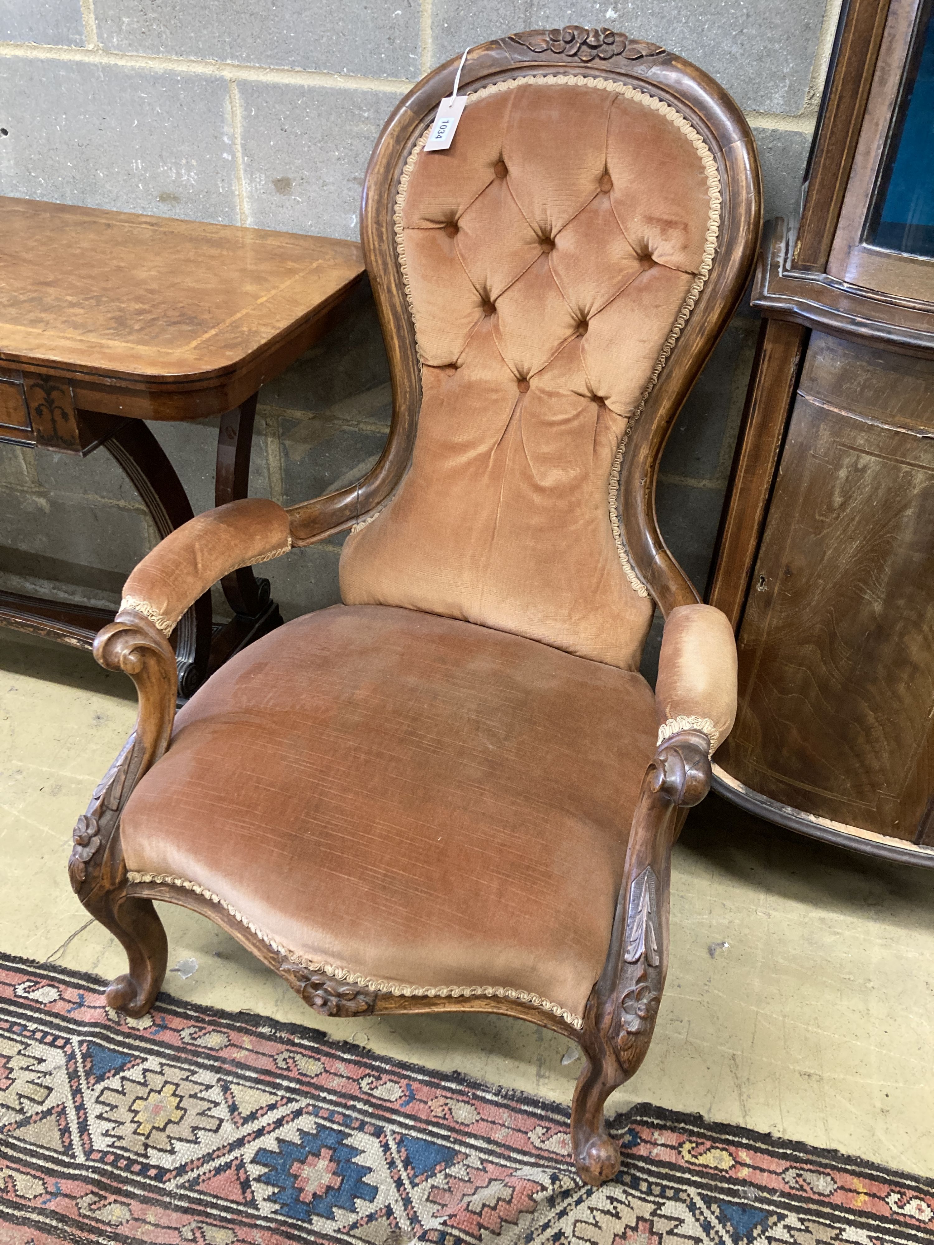 A Victorian walnut spoonback open armchair